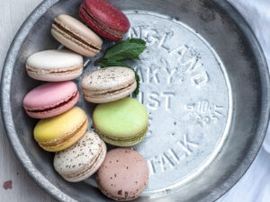 Colorful assorted macarons on a vintage metal tray, close-up view.