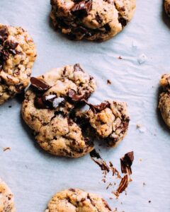 Chocolate chip cookies with melted chocolate on a light background.