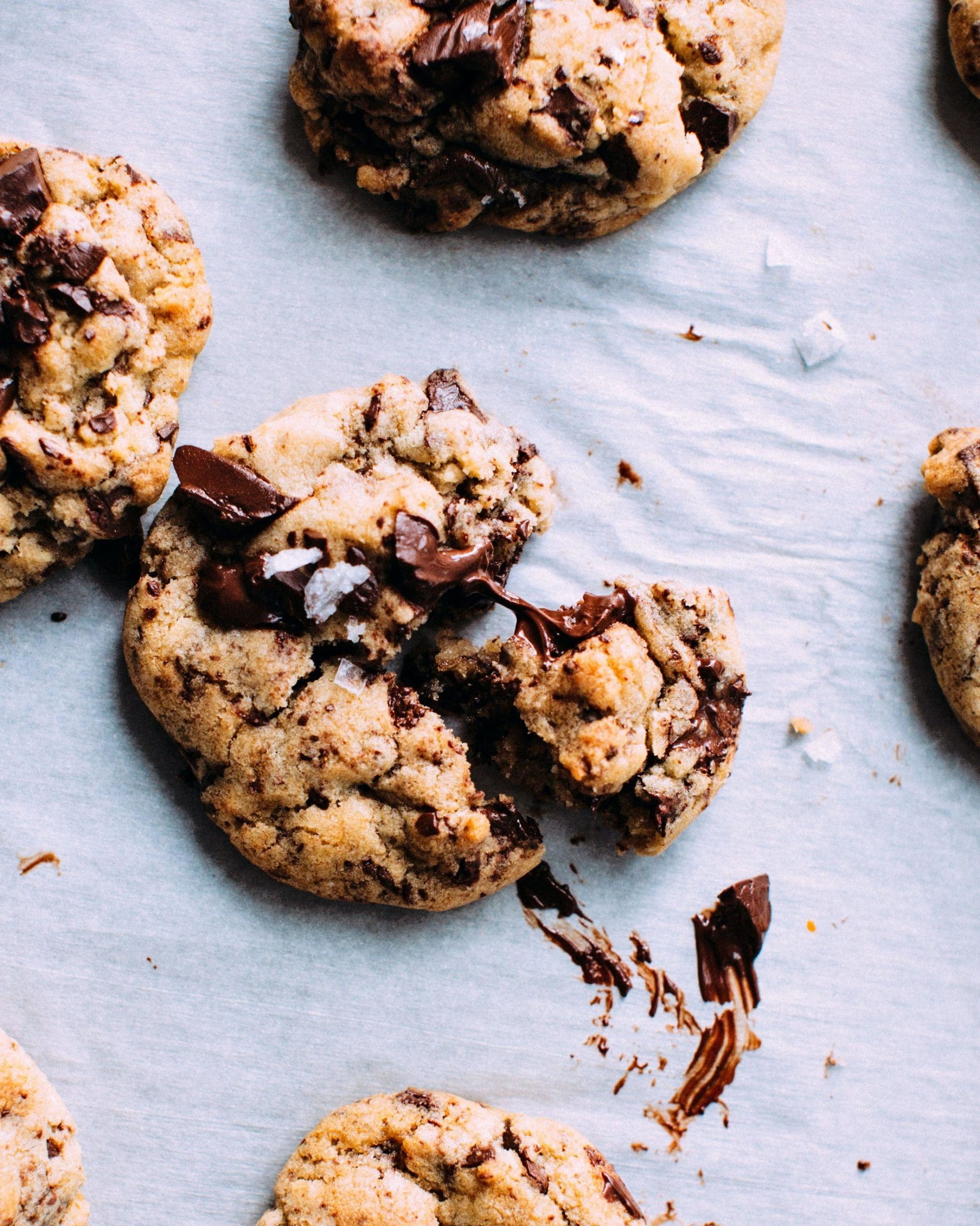 Chocolate chip cookies with melted chocolate on a light background.